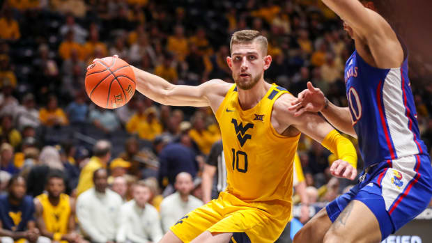 Jan 7, 2023; Morgantown, West Virginia, USA; West Virginia Mountaineers guard Erik Stevenson (10) drives baseline against Kansas Jayhawks forward Jalen Wilson (10) during the first half at WVU Coliseum. Mandatory Credit: Ben Queen-USA TODAY Sports